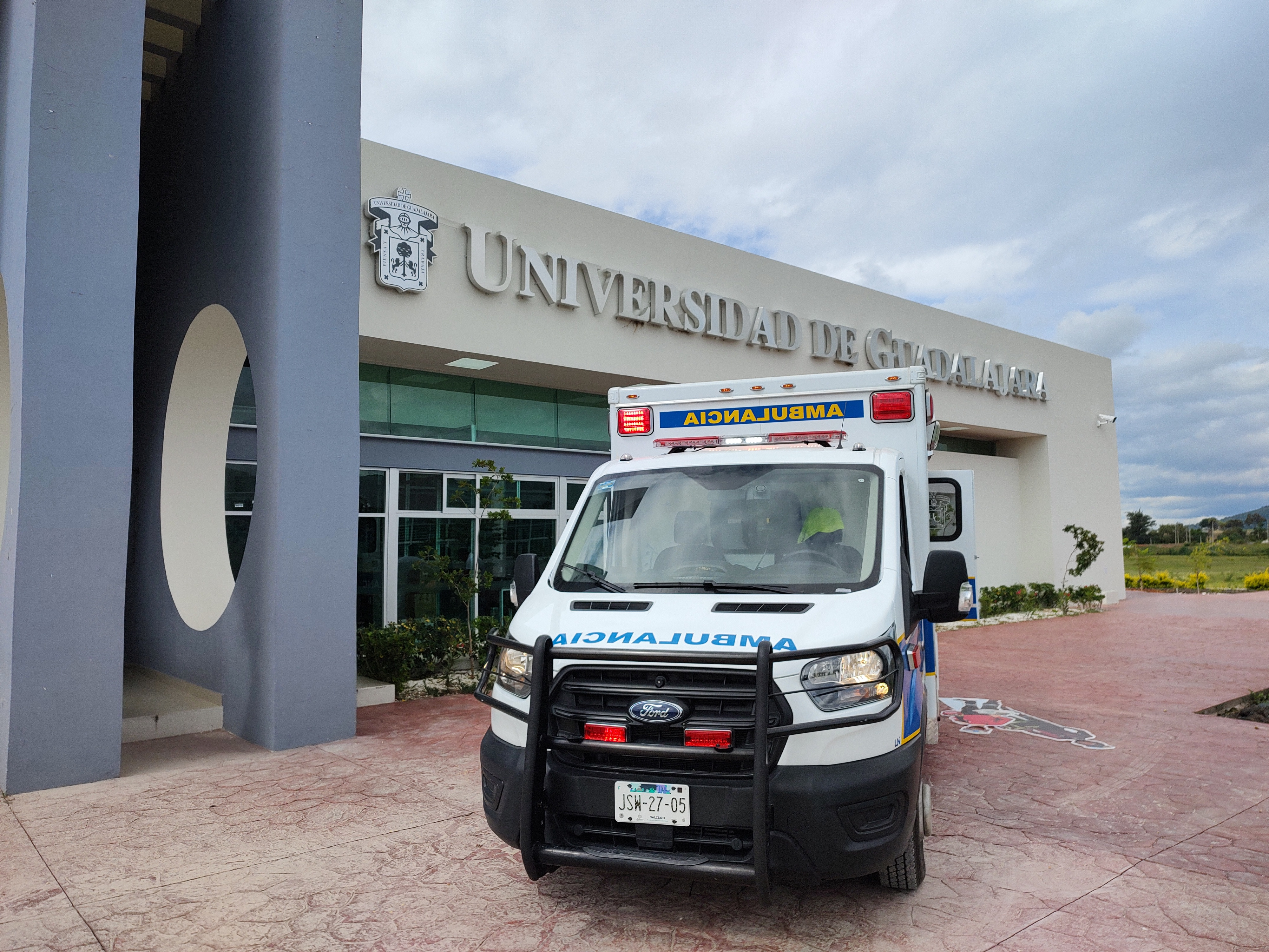 Ambulancia del Hospital Civil de Guadalajara, con la Rectoría del CUTLAJO de fondo 