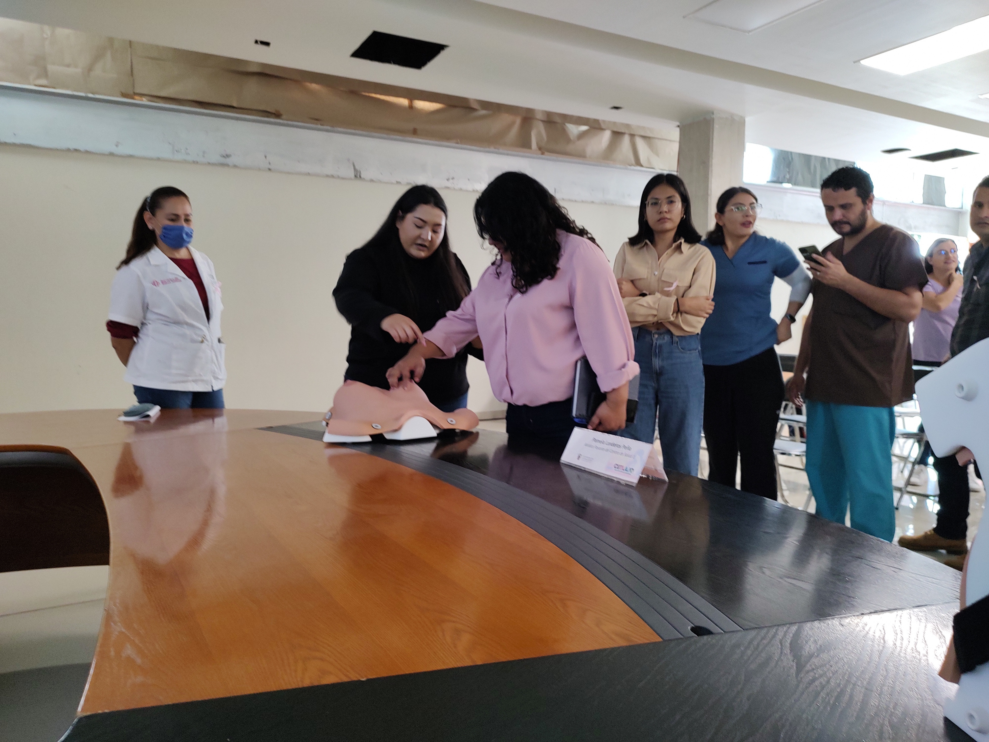 Participantes de las conferencias practicando en maniquíes la exploración de mama