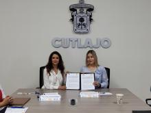 Rectora Leticia Leal y   la directora del CENDI Gabriela Méndez, con el convenio y de fondo el nombre del CUTLAJO