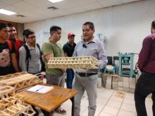 profesor con puente de palitos en sus manos