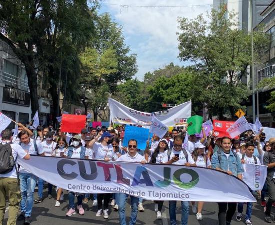 Multitud marchando, con un cartel grande que tiene las letras CUTLAJO