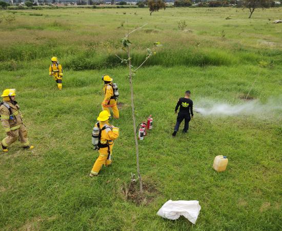 Estudiantes del CUTLAJO con trajes de bomberos, participando en el taller Salvando Vidas, impartido por paramédicos y bomberos. 