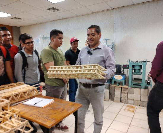 profesor con puente de palitos en sus manos