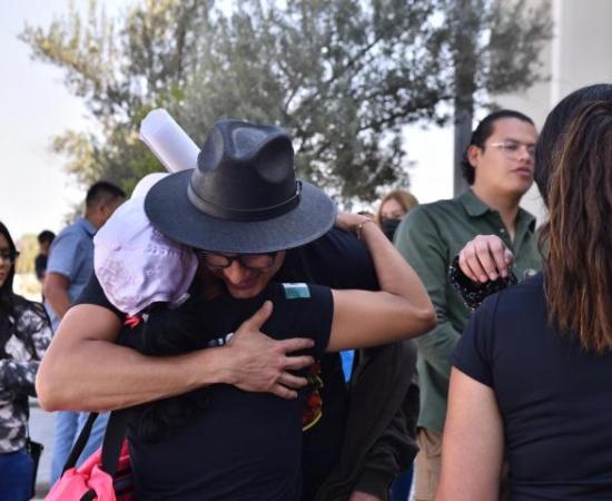 Armenta abrazando a una mujer 