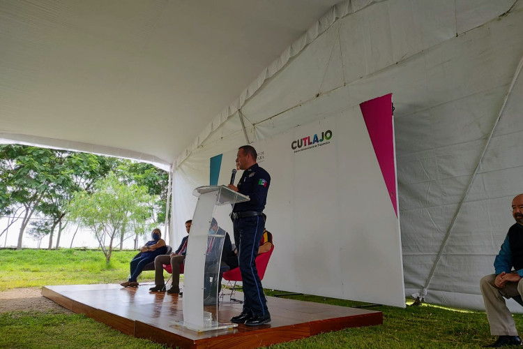 Director de proimidad social de la polica de Tlajomulco de Zuñiga, con un cartel que dice CUTLAJO de fondo