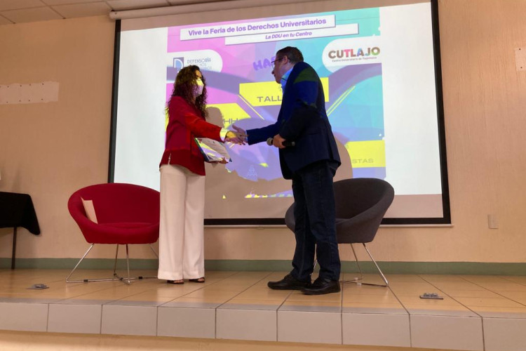 Dra. Leticia Leal y el Dr. Jaime Haro, estrechandose la mano después de entregarse la constancia a la Dra.